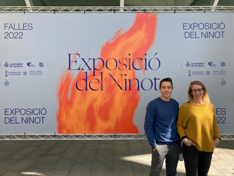 Raül Climent y Elisa Gómez junto a un cartel de las Fallas 2022 diseñado por Estudio Menta.