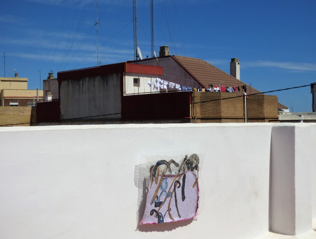 Una de las piezas de la muestra 'Fuerísima colectiva' en Benimaclet, con ropa tendida de otra terraza como fondo. 