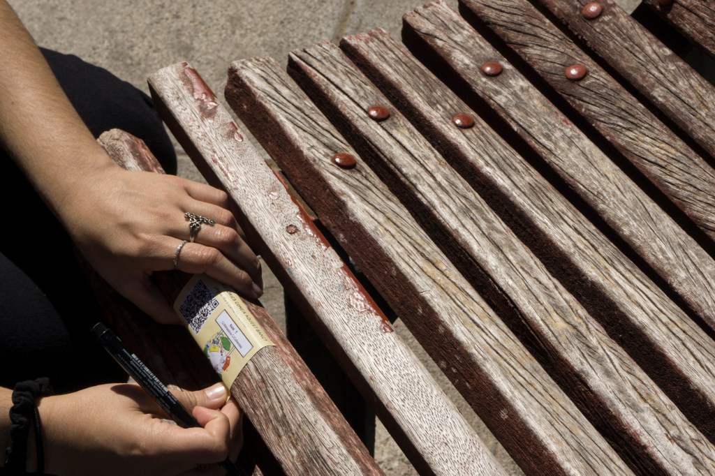 Pegatina de 'El barri ens habita' en un banco de Benimaclet