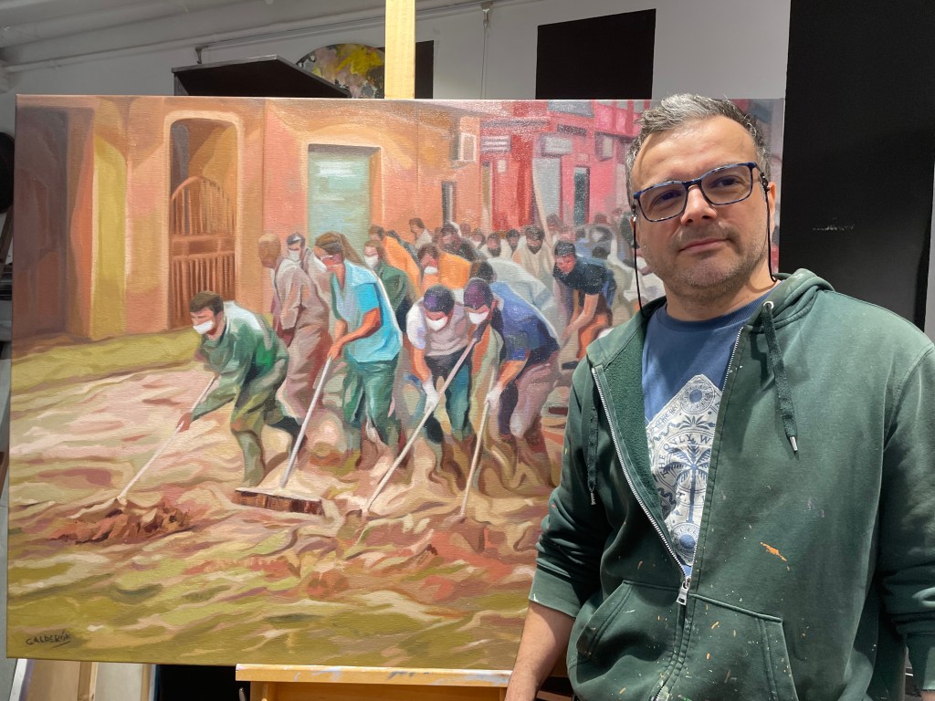 El artista Ariel Calderón frente a su cuadro para ayudar por la dana